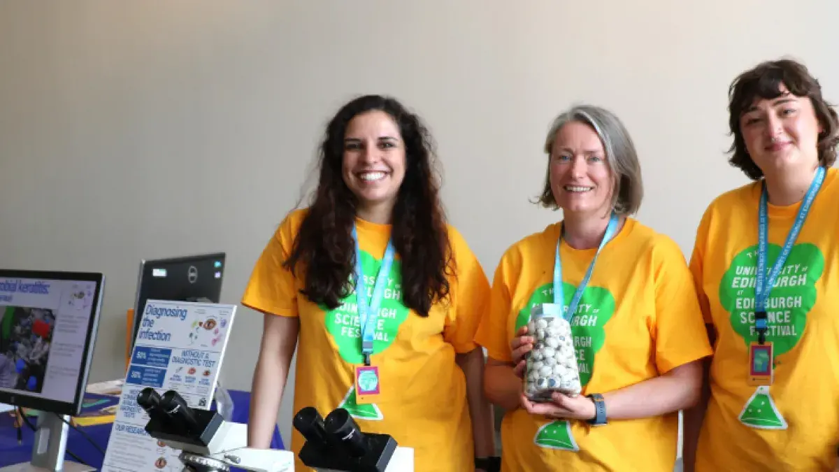 Members of Beth Mills' lab, holding up a jar of eyeballs for 'Guess how many eyeballs are in the jar?'