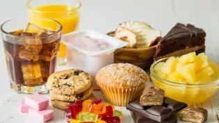 Image of lots of food and drinks high in fructose e.g. chocolate bars, coca-cola and biscuits