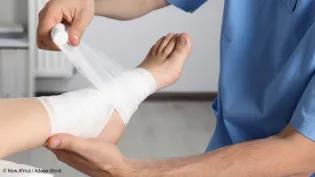 Healthcare professional bandagng a patient's foot