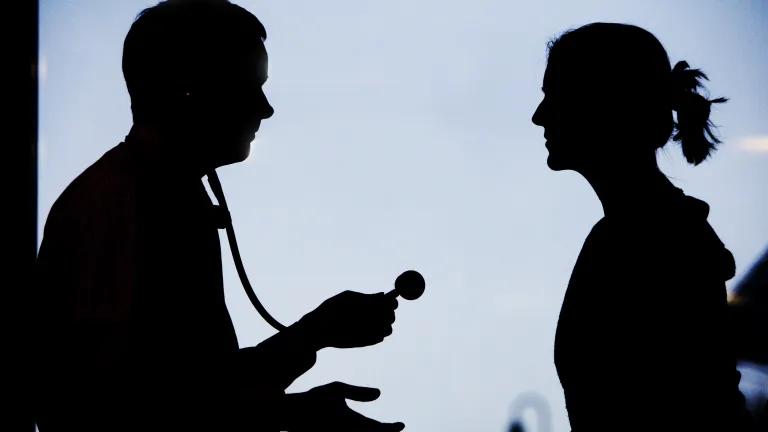 the silhouettes of two people looking at each other. One person is holding a stethoscope.