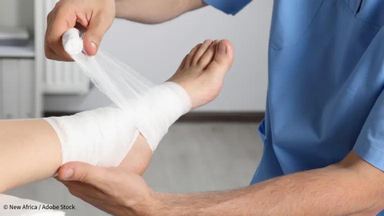 Healthcare professional bandagng a patient's foot