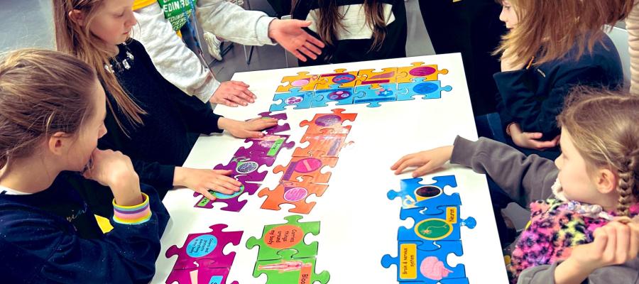 Researcher leading science puzzle activity with a group of under ten year old children