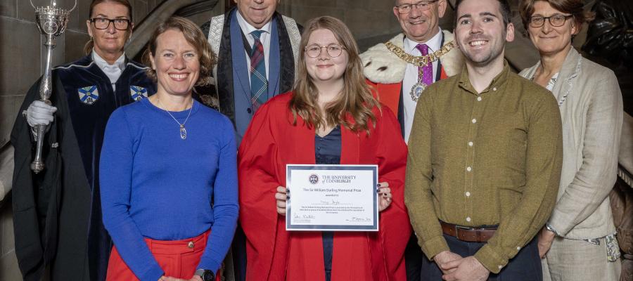 Front row (left to right): Cathy Southworth, Lucy Doyle (in red academic robes holding a certificate), Dom Cairn-Gibson. Back row: Woman in academic robes holding a sceptre, Peter Mathieson (in Principal academic robes), man (in fur lined red robe and chain),  Marieke Hoeve.