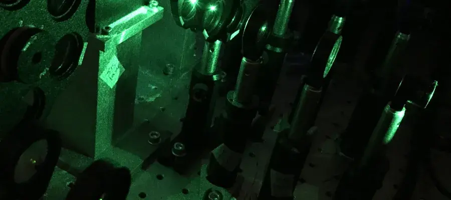 A dark room with chemistry equipment half lit in green. 