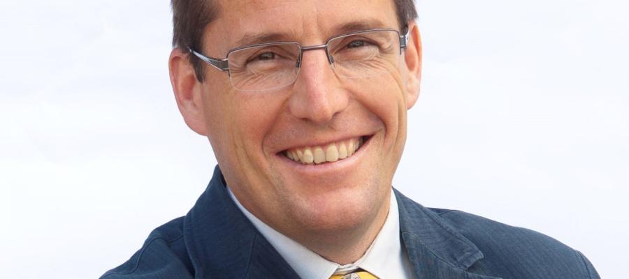 Stephen Gordon wearing a grey suit and smiling