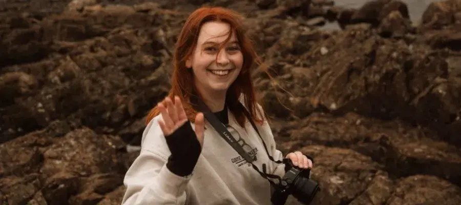 Abbie Lacy-Darrah waving at camera on a windy day
