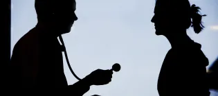 the silhouettes of two people looking at each other. One person is holding a stethoscope.