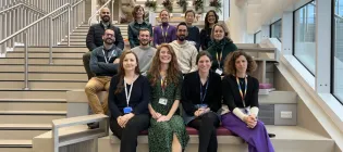 Walmsley lab group members sit on steps within IRR