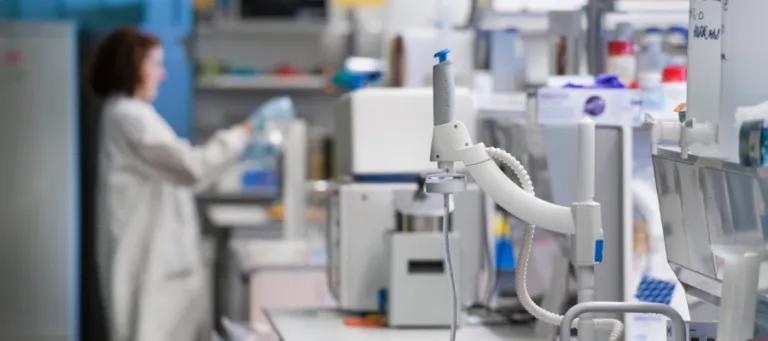 lab equipment in the lab. In the backgrounda scientist works on an experiment