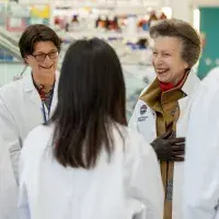 The Princess Royal and a few women wearing lab coats on a facility tour