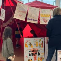 Children wanderign inside a red tent