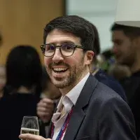 Man smiling in conversation holding champagne glass