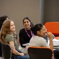 Summer interns engaged by a presentation at a table