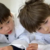 Two boys looking at a screen, engaged