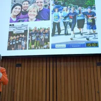 Lorna Marson presenting in front of a screen of fundraising photos