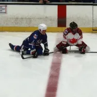 Two ice hockey players kneeling on the ice