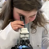 Girl looking down a microscope