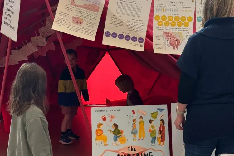 Children wanderign inside a red tent