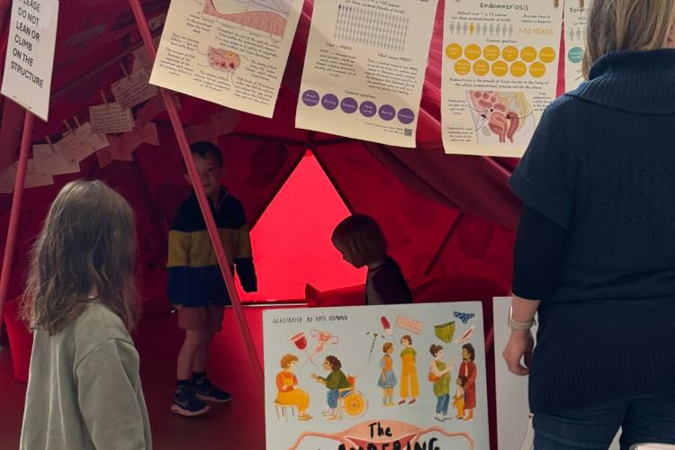 Children wanderign inside a red tent