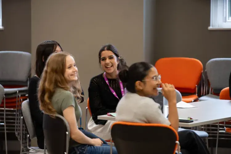 Summer interns engaged by a presentation at a table