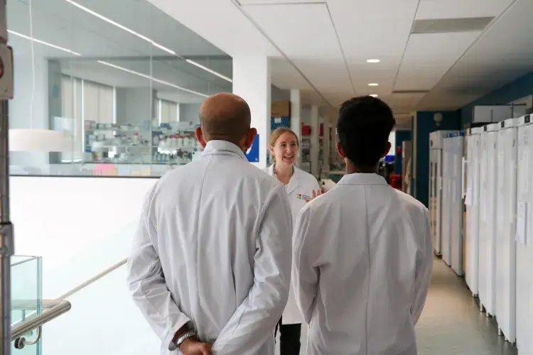 Volunteer speaking to two people whilst giving lab tour