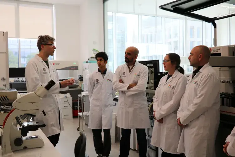 Researcher chatting to group of the public in lab