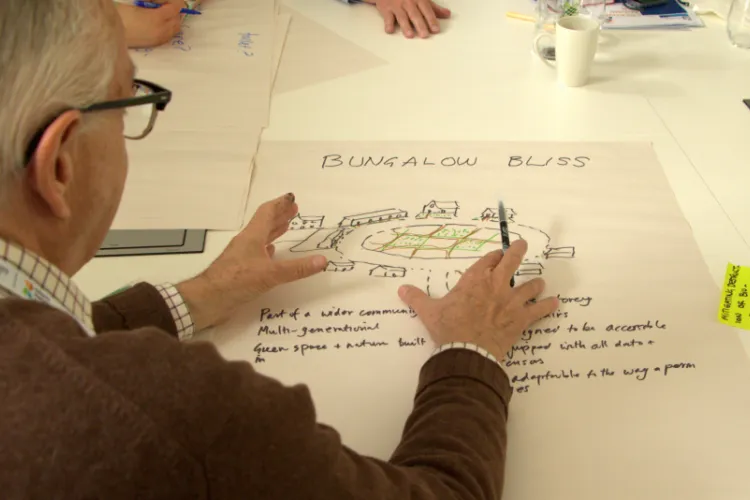 Man drawing on a poster "bungalow bliss"