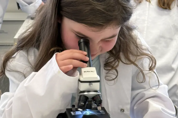 Girl looking down a microscope
