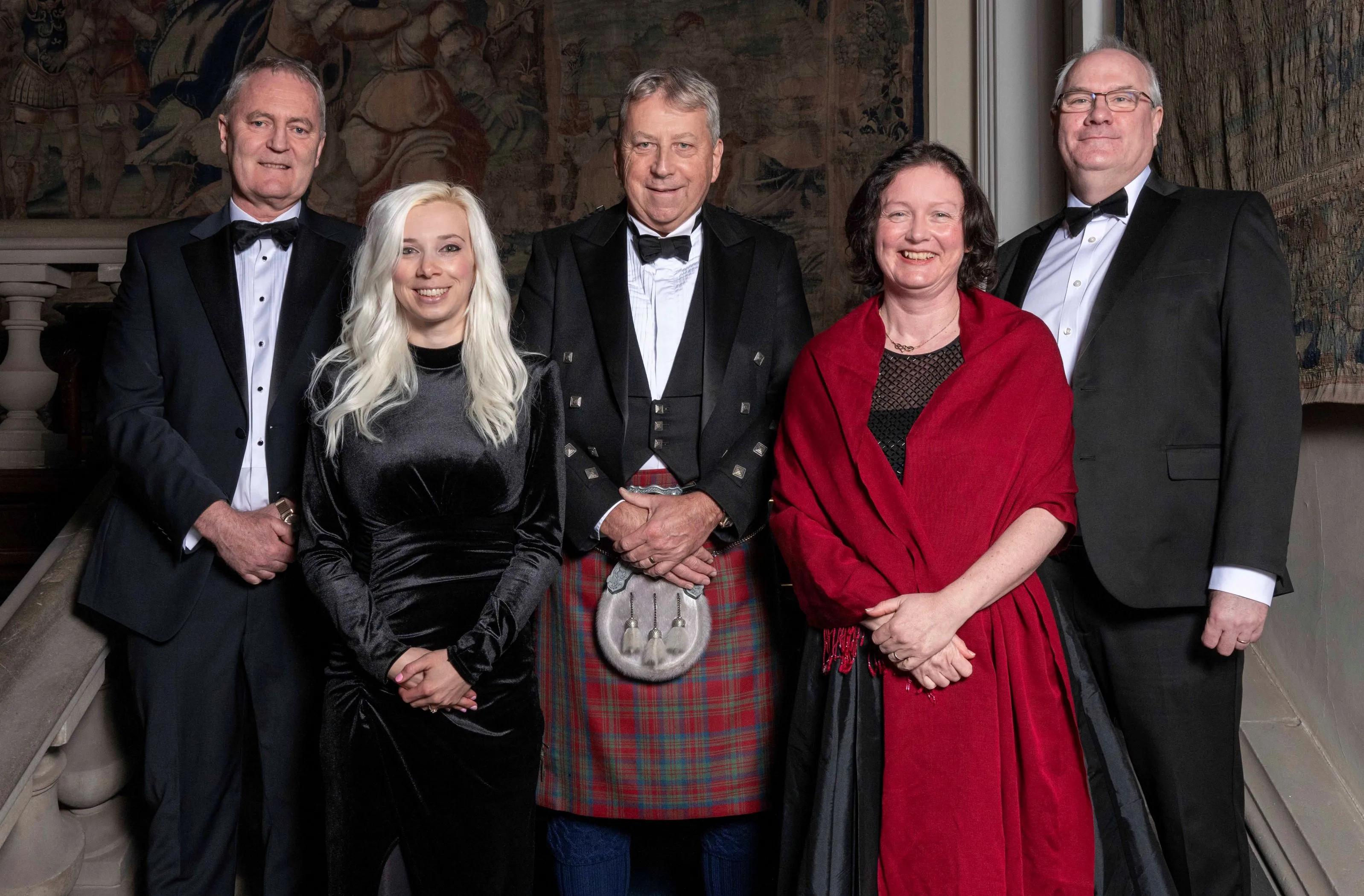 The Principal with Chancellor's Award recipients in formal wear smiling at the camera