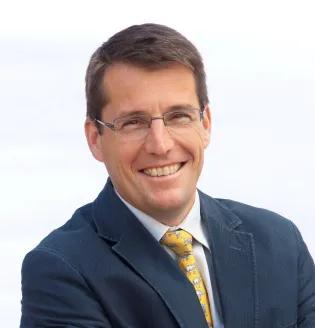 Stephen Gordon wearing a grey suit and smiling