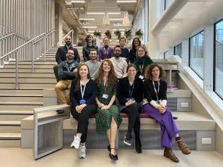 Group photo of Walmsley lab members sitting on steps within IRR