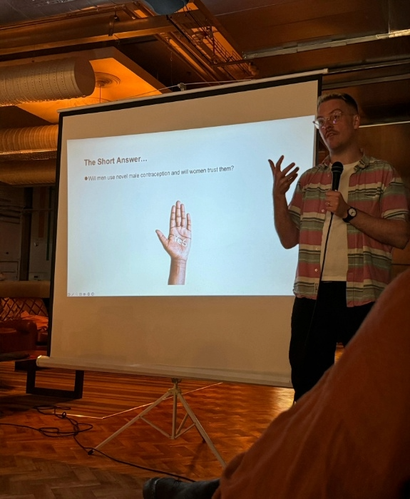 Dr John Reynolds-Wright presenting in front of a screen