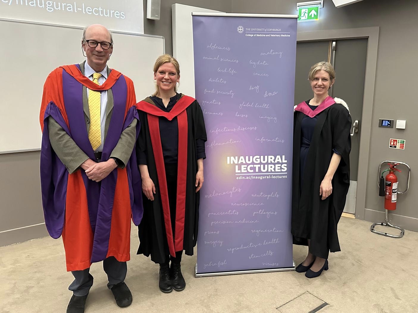 three professors in academic robes stand around a pop up banner that says \"inaugural lectures\"